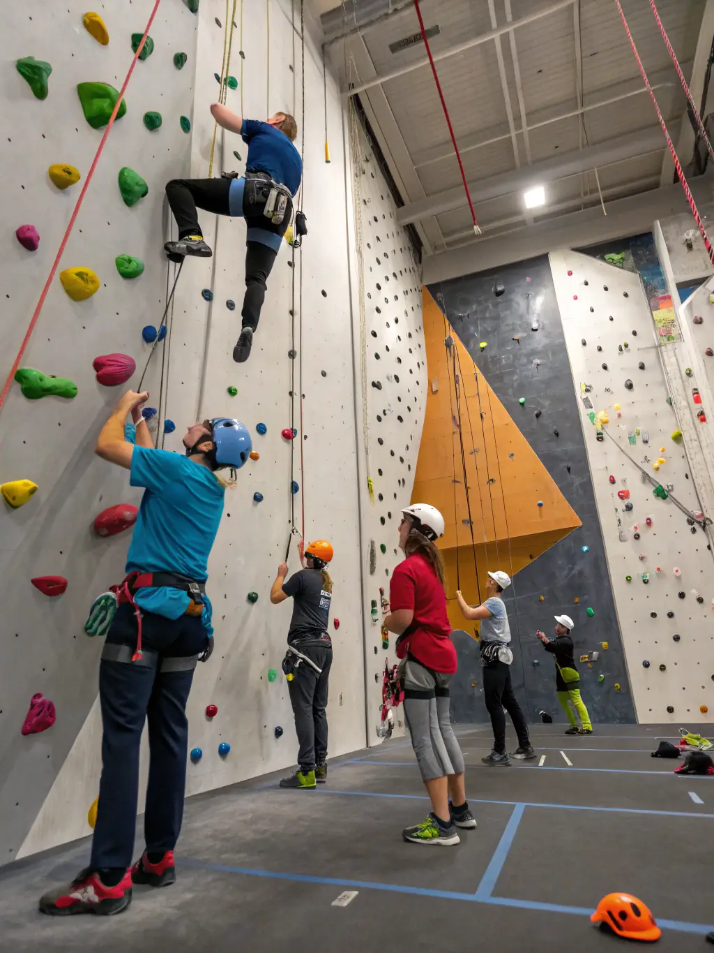 A diverse group of climbers of all ages and skill levels participating in a community climbing event, fostering camaraderie and shared passion for the sport.